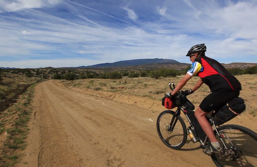 A man rides a bike down a road