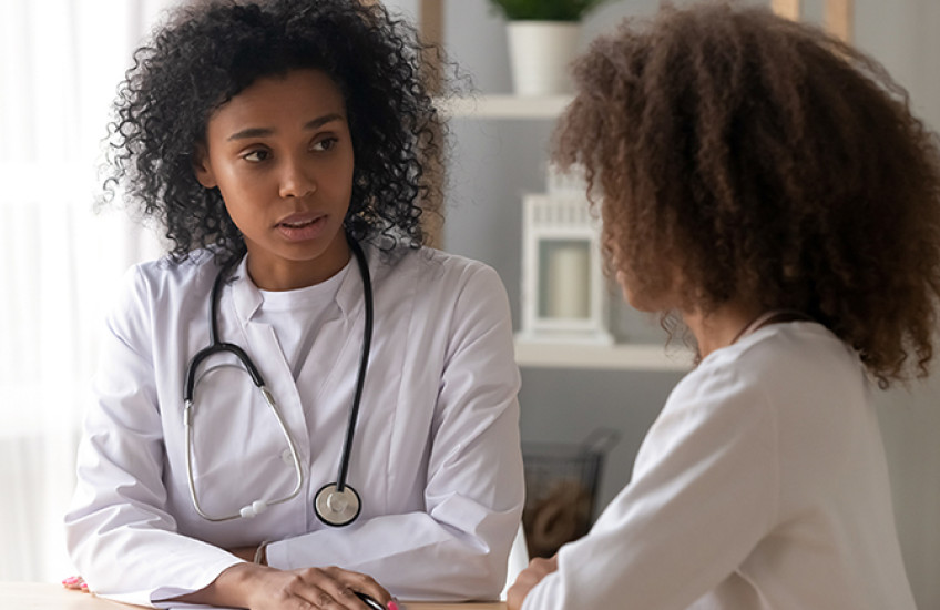 Young Black doctor has serious conversation with pediatric patient of color