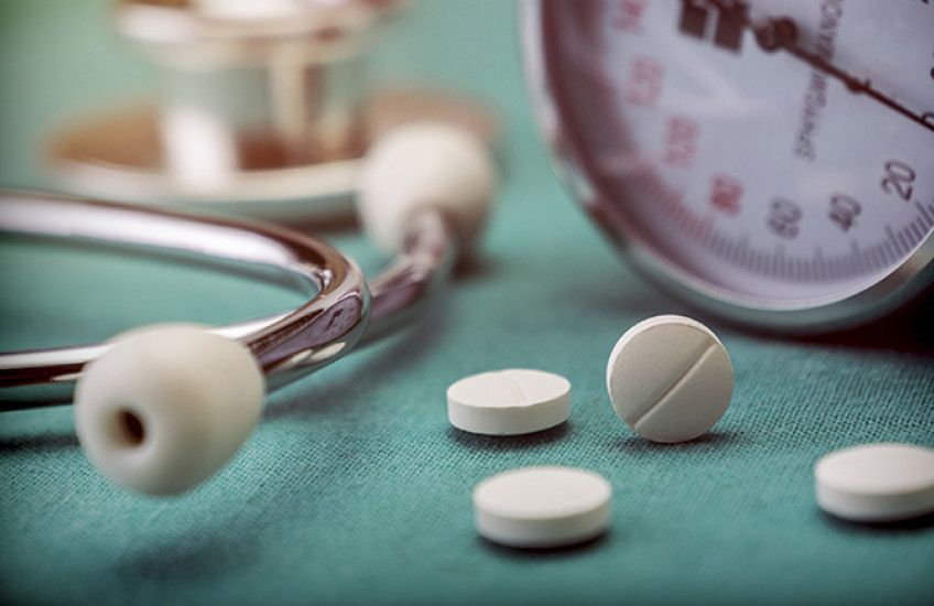 stock image of blood pressure cuff and pills with stethoscope