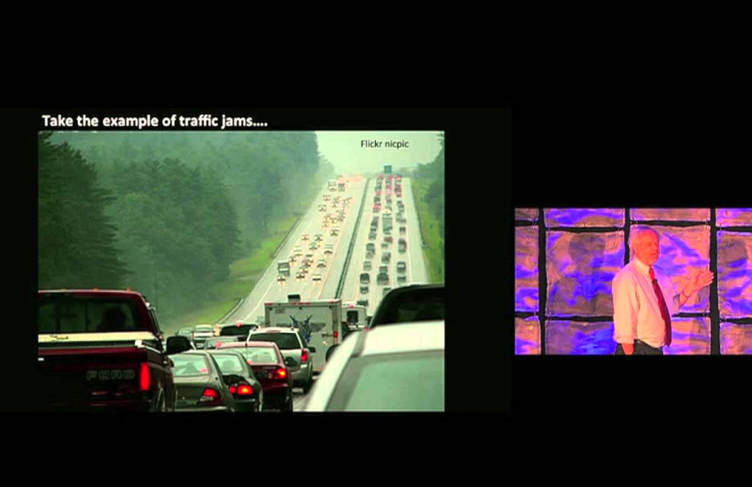 Juan Enriquez points to a picture of traffic