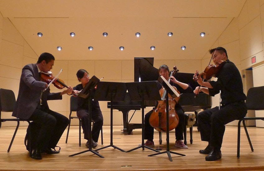 A small group plays string instruments