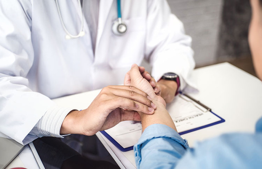 A physician checks a patient's pulse