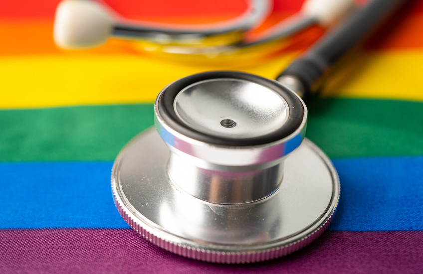 A stethoscope rests on a table covered with  rainbow-colored cloth.