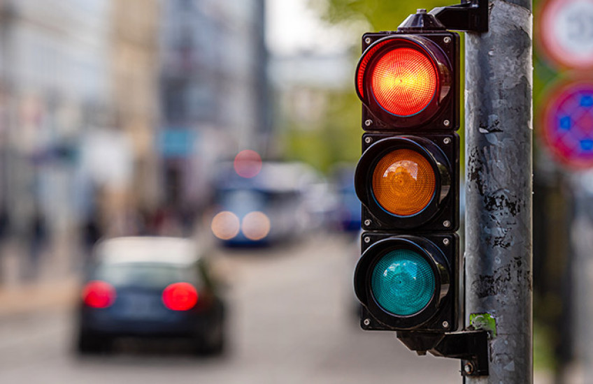 Photo of traffic signal on red, city street blurred out in background