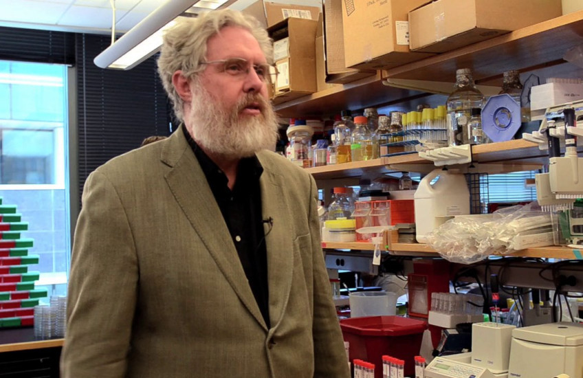 George Church stands in a lab