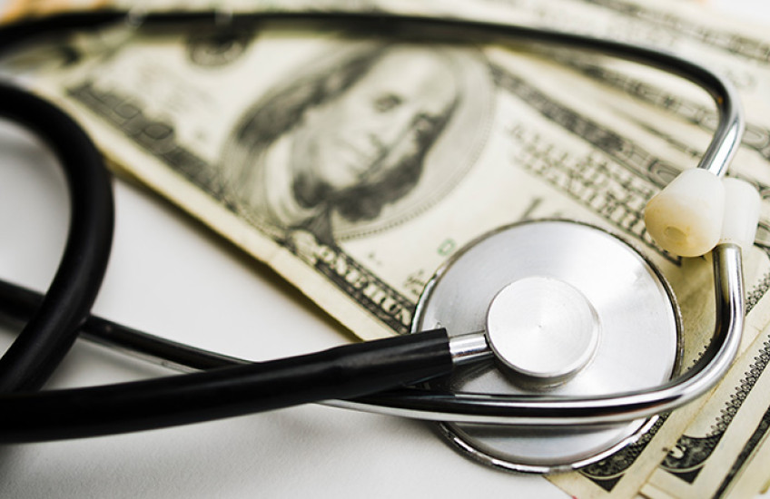 photo of stethoscope on top of money