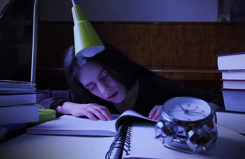A girl falls asleep at her desk