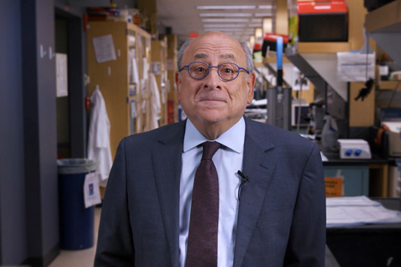 Stuart Orkin, standing in a laboratory wearing a suit, looks into the camera with a slight smile