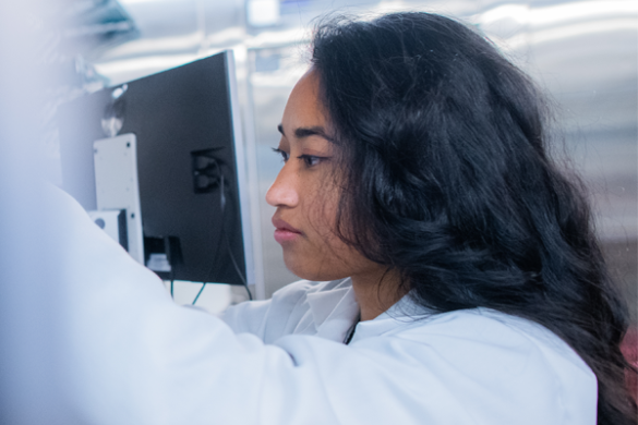 A researcher in a lab coat works with scientific equipment in a laboratory at Harvard Medical School.