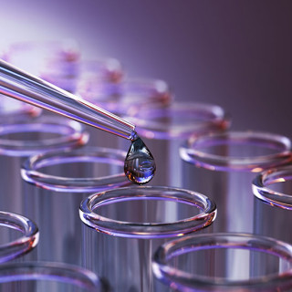 A drop of colorful fluid flows from a pipette into one of many vials in an array.