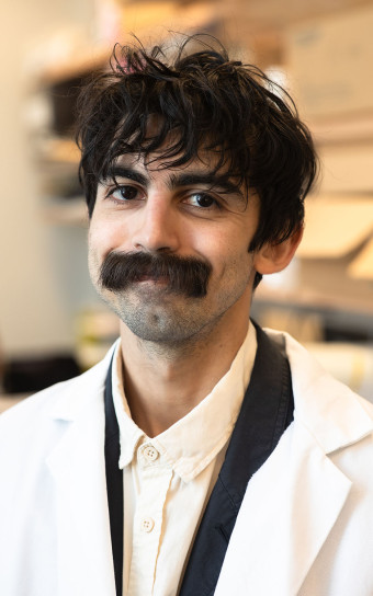Portrait photo of Dionnet Bhatti Mazo in a white lab coat.