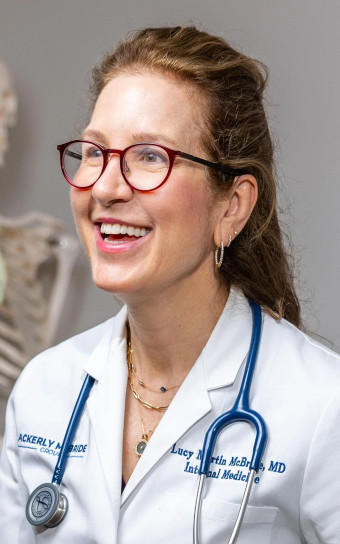 Lucy McBride in a white coat with a model skeleton in the background