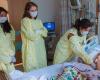 Photo of several HMS students in protective gowns examining a pediatric patient