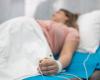 Out of focus image of a pregnant woman on a hospital bed with IV 