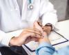 Stock image of a doctor's hands taking a patient's pulse 