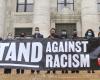 HMS community members holding a 'Stand Against RAcism' banner 