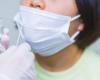 photo of a child with a mask about to get a nose swab for COVID