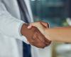 Doctor in a white coat shaking a patient's hand 