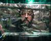 Portrait of a bearded man in glasses through a fish tank he is holding