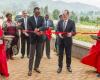 Two men cut a bright red celebratory ribbon.
