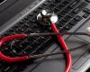 red stethoscope on laptop computer 