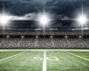 football stadium showing 50 yard line, crowd in seats and lights