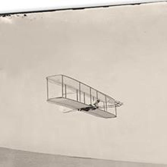 old photo of a biplane in flight