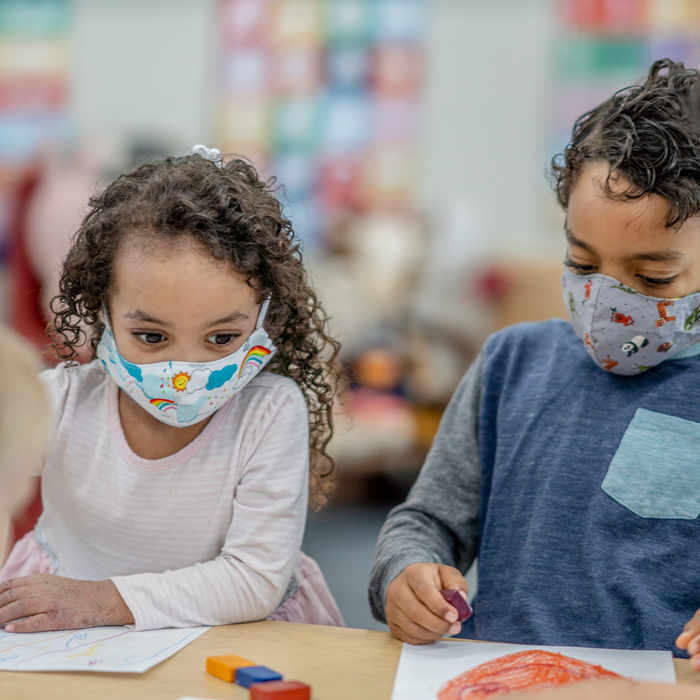 two children wearing masks in a school setting