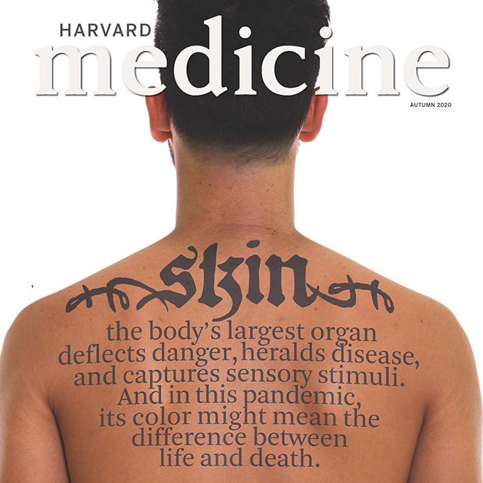 Cover of the Autumn issue of Harvard Medicine, showing a young man's back with tattoo-like writing saying "skin," the issue's theme