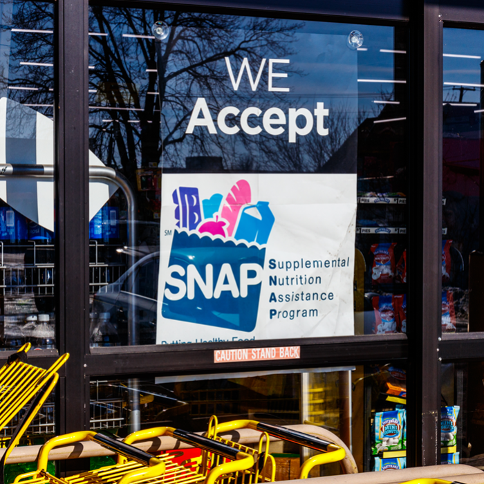 sign in store window indicating SNAP vouchers are accepted