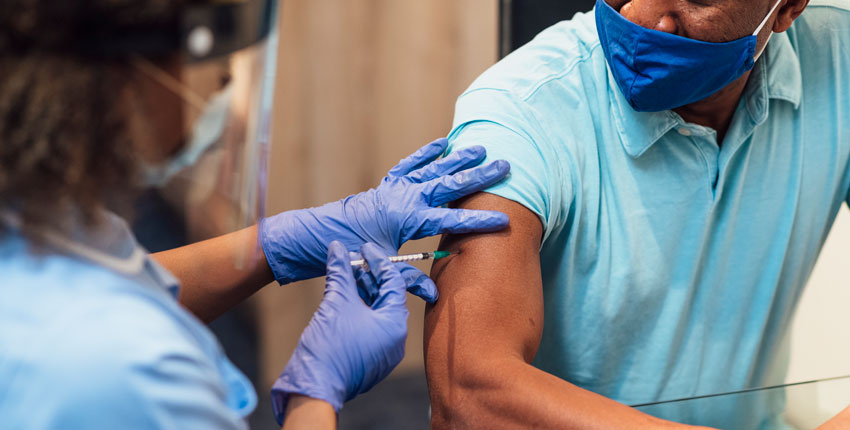 Photo of an African American man getting a vaccination 