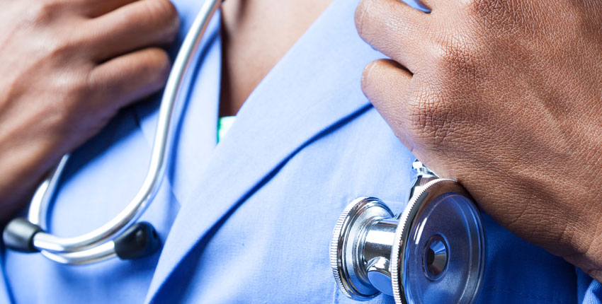 Image of a Black physician, just hands, scrubs and a stethoscope