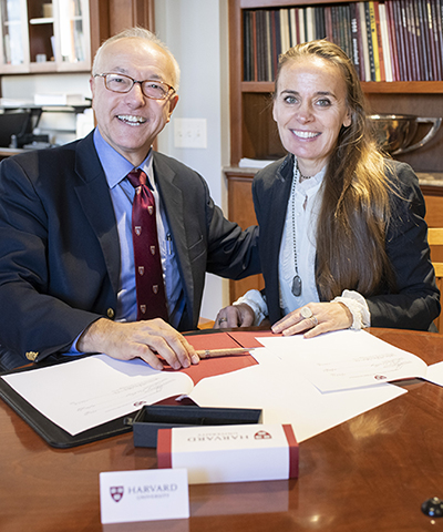 Shot of man and woman in office smiling over a piece of paper and a pen
