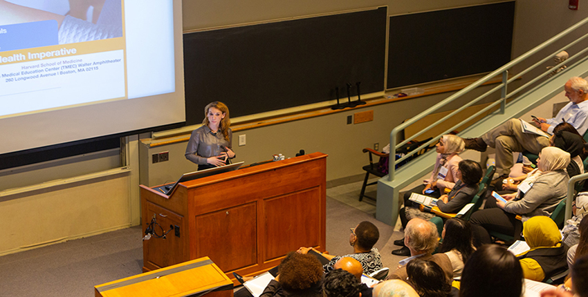 Speaker and audience at "Eliminating Health Disparities" conference