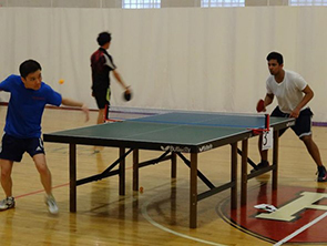 Will Chan playing table tennis, preparing to return the ball to his opponent